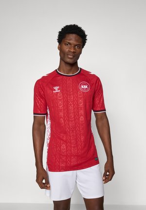 Maillot rouge à manches courtes avec motif texturé, présentant un logo circulaire et des accents latéraux blancs contrastants. Finition noire au col et aux manches.