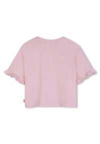 Ροζ ανοιχτόχρωμο κοντομάνικο κοντό πουκάμισο με βολάν στα τελειώματα των μανικιών και μια μικρή κόκκινη ετικέτα στο κάτω αριστερό μέρος.