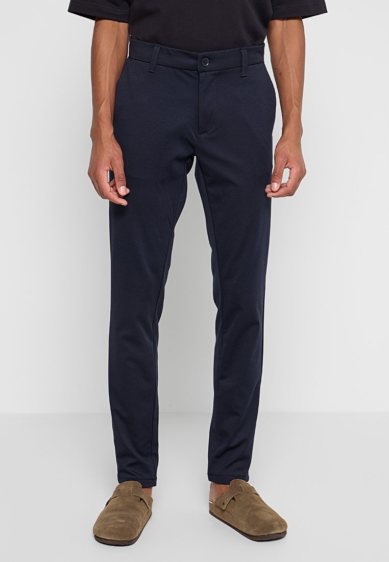 Marinehosen aus stretchfähigem Material. Slim-Fit-Design mit Knopfverschluss, Gürtelschlaufen und flachem Bund. Glatte Textur, keine Muster.