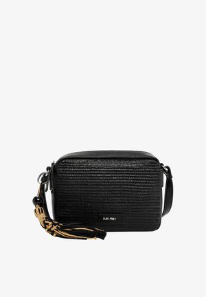 Sort textured crossbody-taske med justerbar rem, dekorativ beige og sort kvast samt lille Suri Frey logo-plaque foran.