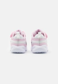 Chaussures de sport roses avec des accents blancs, dotées d'une semelle rembourrée, d'une tige en tissu et d'une languette à l'arrière pour un enfilage facile.