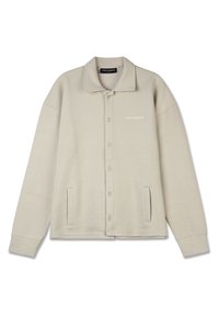 Beige button-up jacket with a textured pattern, large collar, two front pockets, and a subtle logo on the chest. Soft fabric.