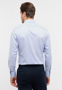 Heren lichtblauwe gestreepte shirt met een knoopsluiting kraag, lange mouwen en een slim fit. Het materiaal lijkt glad, met een subtiele textuur.