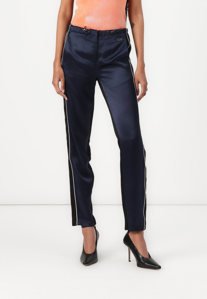 Navy satin pants with black side stripes and white piping, featuring a drawstring waist and a smooth texture for a tailored fit.
