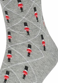 Calze grigie con un motivo a rombi e piccoli motivi di soldatini neri e rossi, realizzate in un tessuto morbido e testurizzato.