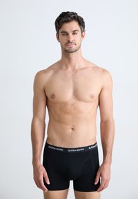 Black boxer briefs with a branded elastic waistband. The fabric has a smooth texture, providing a fitted and supportive design.