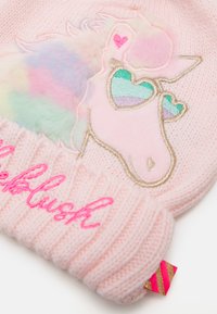 Ροζ πλεκτό καπέλο με σχέδιο μονόκερου που διαθέτει παστέλ χρώματα, κεντητές καρδιές και διπλωμένο ριμπ μανίκι με την ένδειξη "blush" σε ροζ γραφή.