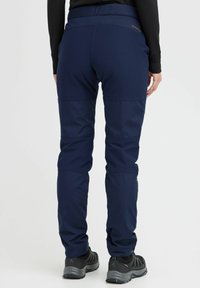Navy outdoor pants made from durable fabric, featuring a high waistband, elastic cuffs, and reinforced knee panels for added strength.