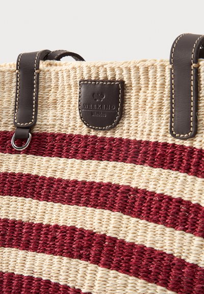 Sac cabas tissé beige et bordeaux à rayures avec des anses en cuir marron foncé et une étiquette logo en cuir cousue indiquant « WEEKEND Max Mara ».