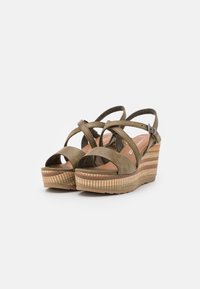 Olijfgroene wedge sandalen met kruislings gestikte bandjes, textuurstof en een meerkleurig gevlochten platform. Verstelbare enkelband.