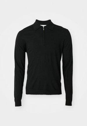 Schwarzes Langarm-Polohemd aus weichem Stoff, mit einem halben Reißverschluss-Kragen und tailliertem Saum. Das Material wirkt glatt und leicht strukturiert.