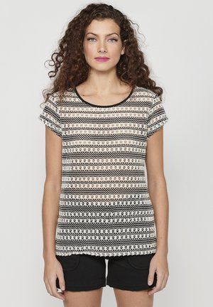 Schwarz-weiß gemusterte Bluse mit kurzen Ärmeln, runder Ausschnitt, transparentem Stoff und geometrischen Designs.