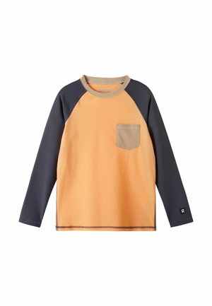 Koszulka raglan z długim rękawem, pomarańczowym korpusem, ciemnoszarymi rękawami, beżowym kołnierzem i kieszenią na piersi oraz logo na mankiecie lewego rękawa.