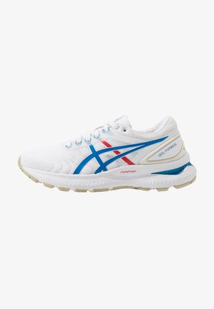Chaussure de course blanche avec des rayures bleues et rouges, semelle amortie portant l'inscription FlyteFoam, et logo Gel-Nimbus sur le talon.
