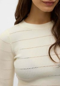 Maglione a coste di un beige chiaro con strisce orizzontali e piccole aperture. Design classico con scollatura a girocollo e una texture morbida.