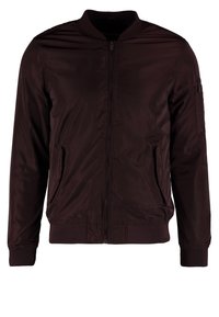 Giacca bomber di un intenso borgogna, materiale in nylon liscia, zip frontale, polsini e orlo a coste, tasche laterali e una tasca con zip sulla manica.