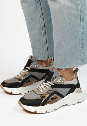Sportieve sneakers in grijs, zwart en metallic goud. Voorzien van mesh stof, een gevoerd schouderdeel, witte veters en een dikke, witte zool.