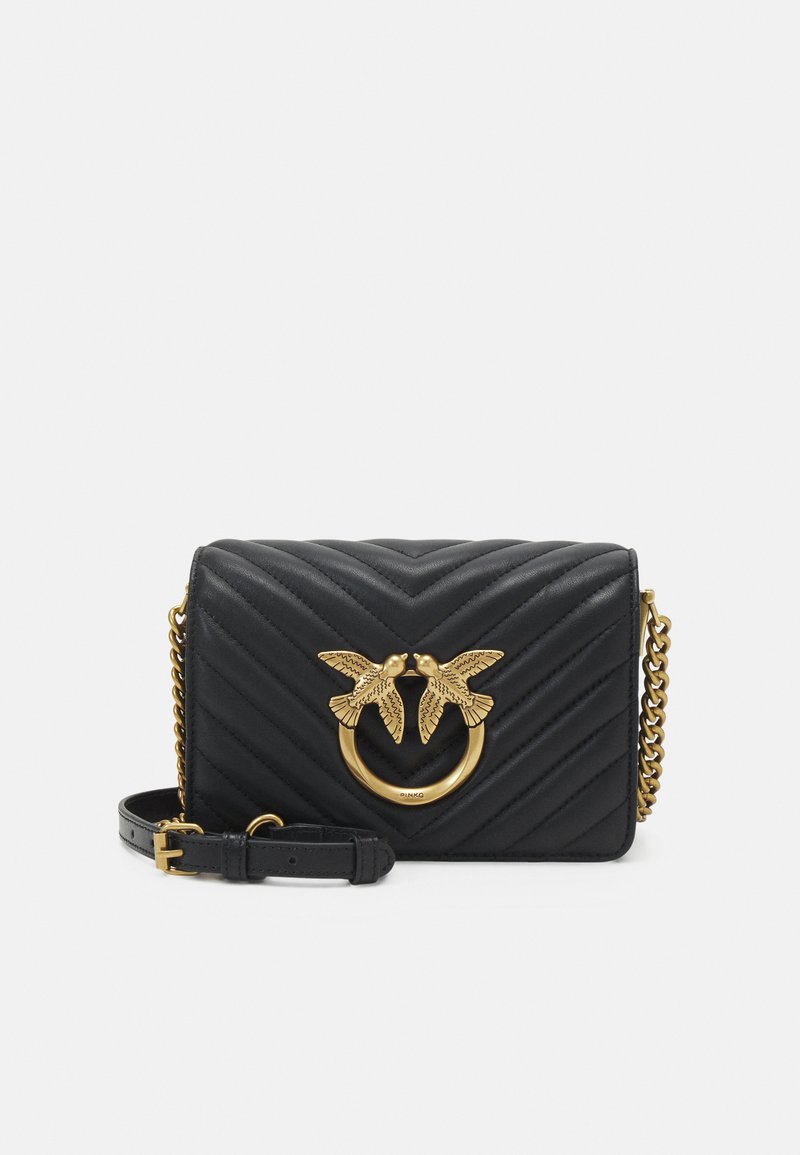 Borsa a mano in pelle nera con motivo a chevron trapuntato, accentata da un uccello in tono oro e hardware a cerchio; include una tracolla a catena rimovibile.