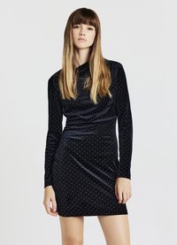 Schwarzes Samtkleid mit langen Ärmeln, taillierter Form und silbernen Punktmustern. Glatte Textur mit einem dezenten Ausschnitt.