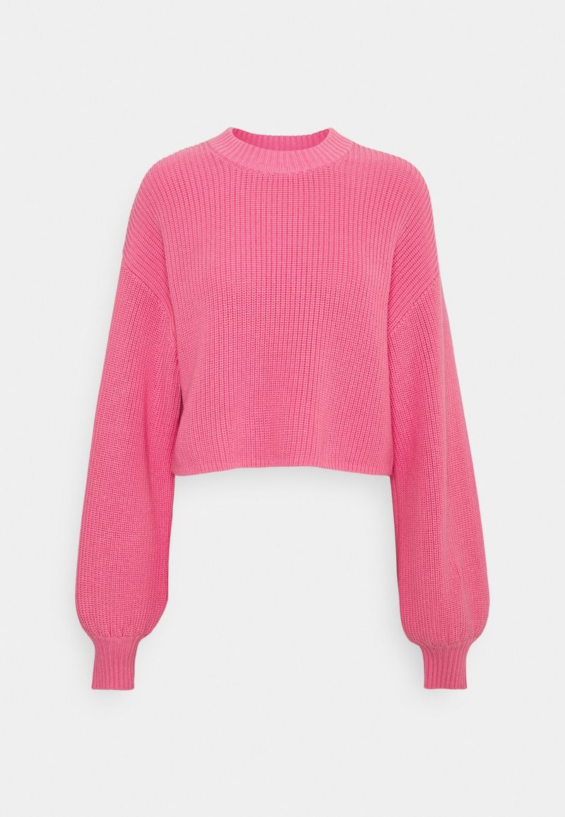 Kort rosa stickad tröja med ribbad textur, långa ballongärmar och rund halsringning. Materialet verkar mjukt och elastiskt.