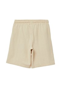 Beige Baumwollshorts mit elastischem Bund und vertikal gerippter Textur. Verfügt über seitliche Schlitze für verbesserte Beweglichkeit und Komfort.