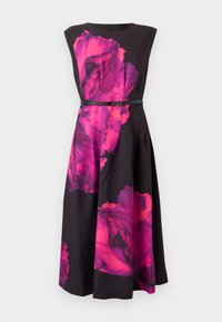 Robe noire avec un motif floral rose vif, sans manches avec un col rond, taille cintrée avec une ceinture mince, et silhouette fluide.