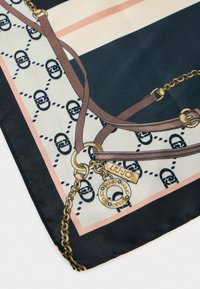 Foulard di seta con un motivo geometrico nelle tonalità di blu navy, pesca e crema. Dettagli includono cinturini marroni e accentuazioni in metallo.