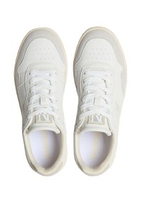 Sneaker bianche con tomaia in pelle liscia, dettagli perforati, lacci piatti e suola in gomma color crema. Presenta un marchio sulla linguetta.