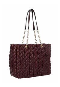 Sac en toile matelassé bordeaux avec une texture tissée, chaîne en argent et poignées en cuir, comportant un accent circulaire près du haut.