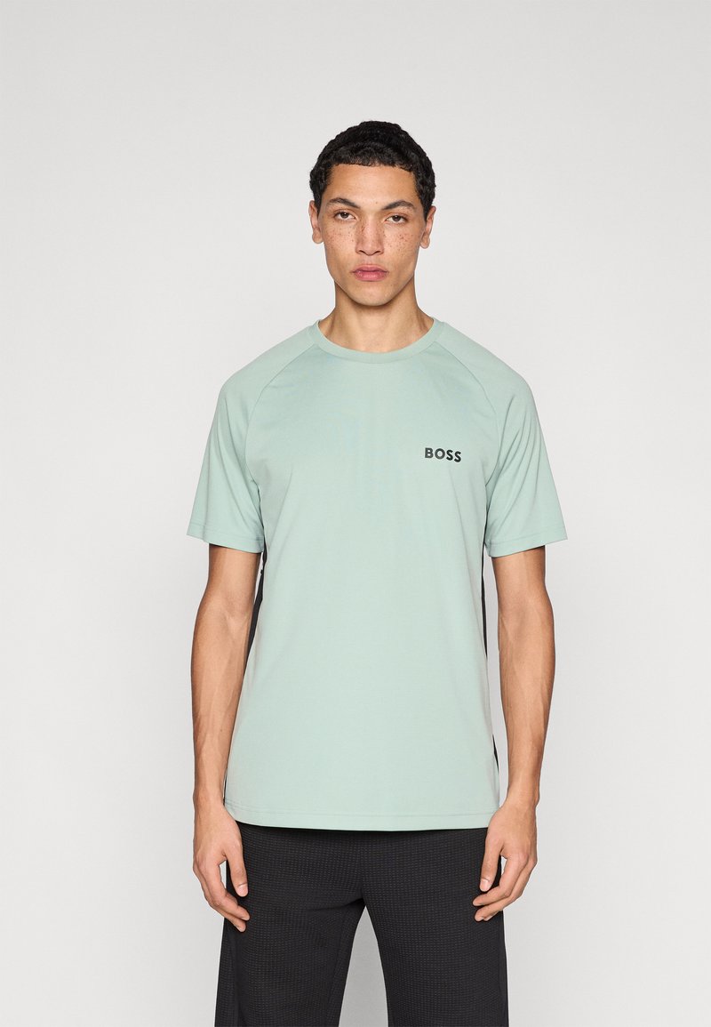 Lichtgroen T-shirt met ronde hals en raglanmouwen. Voorzien van een klein zwart "BOSS"-logo op de borst. Gladde textuur, gemaakt van zachte stof.