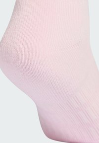 Calcetín rosa claro hecho de un material suave y elástico, que presenta una textura acanalada y una forma ajustada, diseñado para cubrir el tobillo.