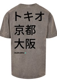 Gray oversized t-shirt with crew neck. Features large Japanese text on the back and a small blue star graphic near the hem. Faded texture.