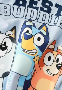 T-krekls ar gaiši zilu audumu un multfilmu zīmējumu ar trim suņiem: melno un balto, zilo un oranžo, ar tekstu "LABĀKIE DRAUGI".