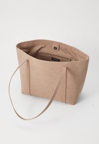 Beige Tragetasche aus weichem synthetischem Material, mit langen Griffen, einem Druckverschluss und einer Innentasche mit Reißverschluss.