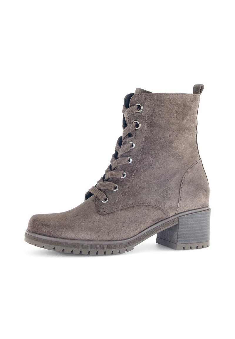 Stivaletto in suede marrone, con punta arrotondata, lacci frontali, linguetta per il rilascio e tacco a blocco texturizzato. Suola a trama per una maggiore aderenza.