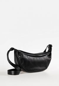 Borsa a spalla in pelle nera con design curvo, tracolla regolabile e texture liscia. Presenta una chiusura con zip e un aspetto minimalista.