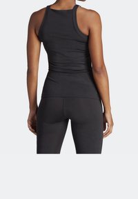 Schwarzes sportliches Tanktop mit figurnahem Design, Racerback-Stil und glatter Textur; getragen mit passenden schwarzen Leggings, von hinten gesehen.
