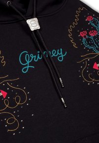 Sudadera negra con bordado colorido en turquesa, rojo y dorado, con diseños intrincados que incluyen cactus y acentos decorativos.