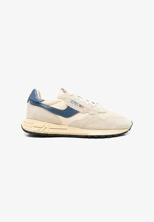 Sneakers in suede beige con dettagli navy, caratterizzate da un design testurizzato, lacci bianchi e suola in gomma nera con battistrada decorato.