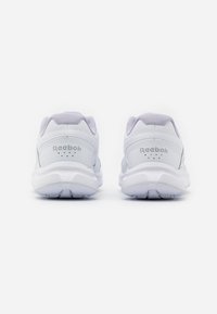 Paire de chaussures de sport blanches Reebok vues de dos, avec semelles rembourrées et colliers matelassés sur fond blanc.