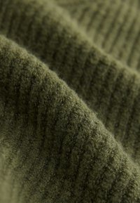 Tela de color verde oliva con patrón acanalado; textura suave y tejida, con un aspecto esponjoso y un ligero brillo.