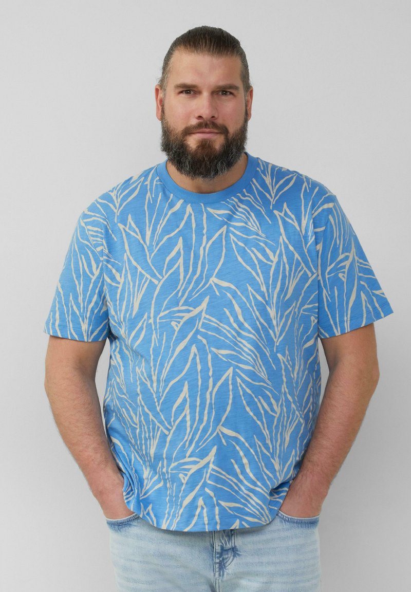 Hellblaues T-Shirt mit kurzen Ärmeln und einem weißen Blättermuster. Aus weichem Stoff gefertigt, mit rundem Ausschnitt und lockerer Passform.