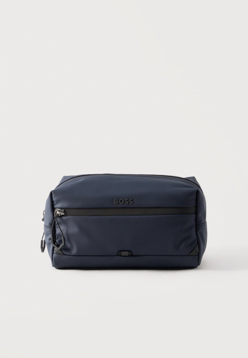 Συμπαγής τσαντάκι καλλυντικών BOSS σε σκούρο μπλε με μπροστινή τσέπη με φερμουάρ και μαύρο τράβηγμα φερμουάρ, σε απλό ανοιχτό φόντο.