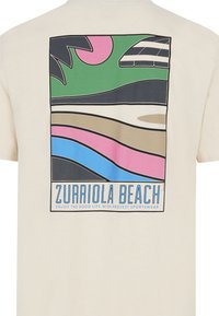 Crèmfaret t-shirt med et multicolor grafisk design med bølger, palmetræer og teksten "ZURRIOLA BEACH" på ryggen.