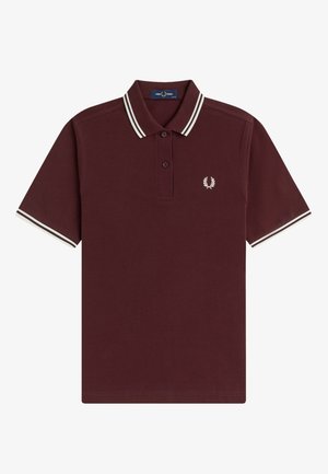 Dunkelrotes Poloshirt mit kurzen Ärmeln, weißen Doppelstreifen an Kragen und Ärmelsäumen, zwei Knöpfen und kleinem weißen Lorbeerkranzlogo auf der Brust.