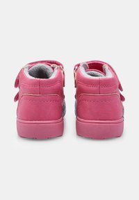 Růžové semišové tenisky s dvojitými nastavitelnými popruhy, šedým fleecovým podšívkem a texturovanou gumovou podrážkou, z pohledu zezadu.