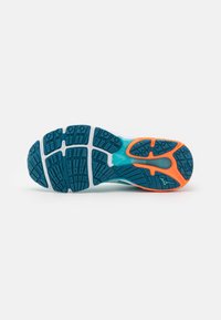 Suela de zapatilla de correr con una superficie de goma azul texturizada, que presenta un acento naranja y surcos estampados para tracción.