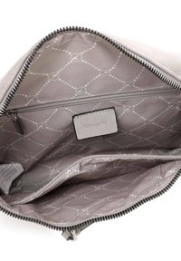 Interno di una borsa in tessuto grigio con un motivo geometrico grigio chiaro, tasca con zip e etichetta; texture liscia con rivestimento morbido.