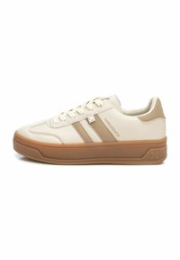 Zapatillas beige con tres franjas marrones, suela de goma, parte superior de cuero vegano texturizado y cierre de cordones. Logo sutil en el lateral.