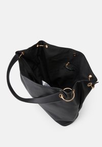 Black leather tote bag with a textured exterior, gold hardware, and a spacious interior featuring a zip pocket and fabric lining.